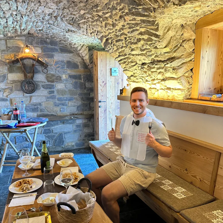 Happy tourist ready to enjoy traditional Italian food in a rustic stone trattoria on Lake Como