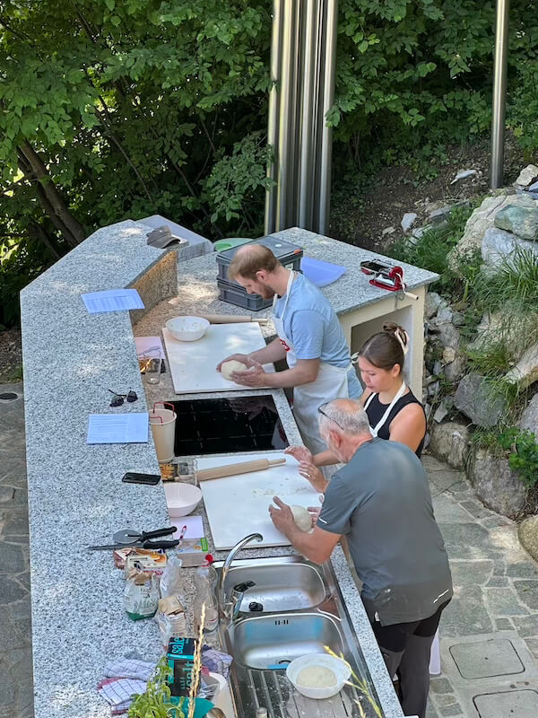 Guests kneading and preparing pizzas in the outdoor kitchen at Baita TreeB in Bellagio.