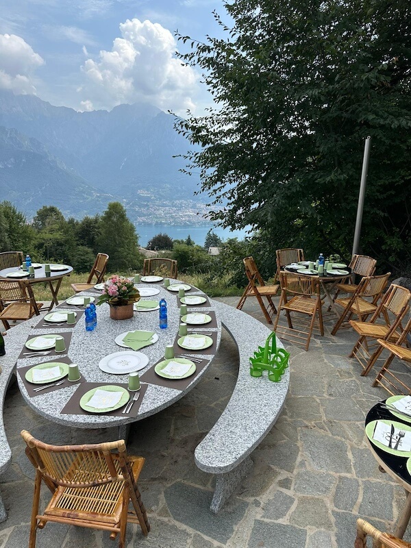 Outdoor tables and chairs with views of Lake Como and the surrounding mountains.