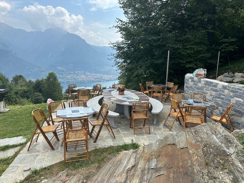 Outdoor tables with panoramic Lake Como views from Baita TreeB in Bellagio.