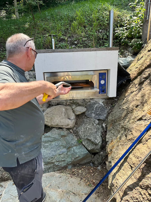 Outdoor stone pizza oven in use during a cooking class at Baita TreeB in Bellagio.