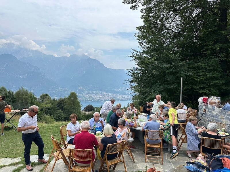 Group enjoying an outdoor lunch with Lake Como views at Baita TreeB in Bellagio.